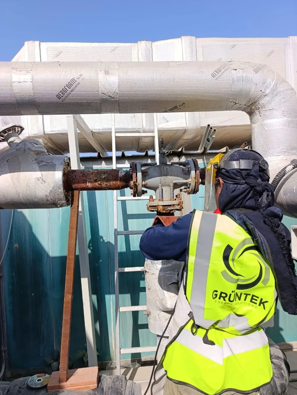 Grüntek engineer working on chilled-water pipework on site